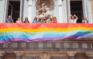 Desplegament de la bandera LGTBI+ a la balconada principal del Palau de la Generalitat. Fotografia distribuïda per la Generalitat de Catalunya. Autor Arnau Carbonell